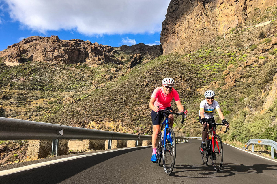 Pair of cyclists enjoying sunny climb on full support guided road cycling tour of Gran Canaria with Marmot Tours