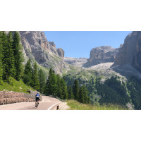 A cyclist descends a mountain road through stunning Dolomites scenery on Marmot Tours guided road cycling holiday