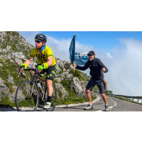 Marmot Tours cycling guide supporting cyclist on Alto de l'Angliru cycling climb in Asturias region northern Spain