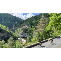 Cyclists on a road high above a deep river gorge in south France on Marmot Tours group cycling holiday.